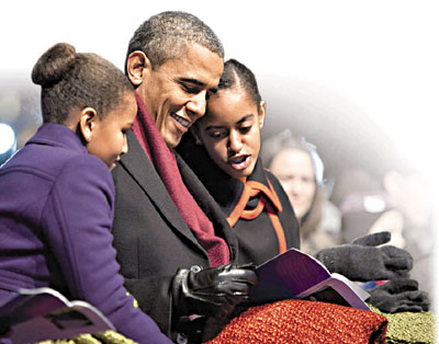 US President Obama and his daughters look at the program during the lighting of the National Christmas Tree in Washington
